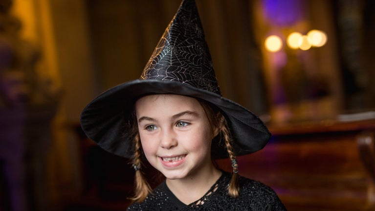 Young girl dressed in a witch's hat